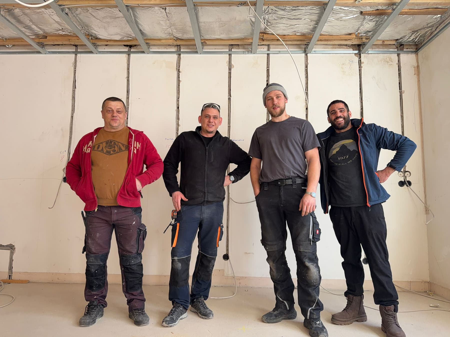 Vier Mitarbeiter von Solarma SHK & Bau in Arbeitskleidung auf einer Baustelle im Innenausbau